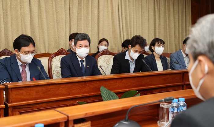 마스크를 쓴 사람들이 테이블에 앉아 있는 모습